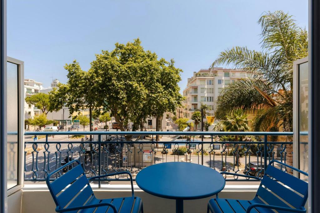 a view from a balcony with a blue table and chairs at Yelo Promenade Hotel Magnan, Sonder by Marriott Bonvoy in Nice