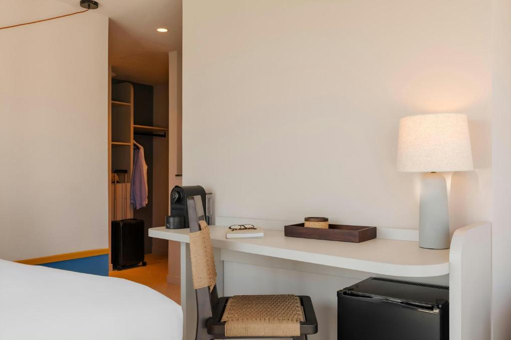 a bedroom with a desk with a bed and a lamp at Yelo Promenade Hotel Magnan, Sonder by Marriott Bonvoy in Nice