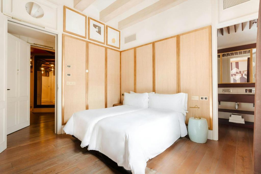 a bedroom with a large white bed and wooden floors at DO Plaça Reial Hotel Gothic Quarter, Sonder by Marriott Bonvoy in Barcelona