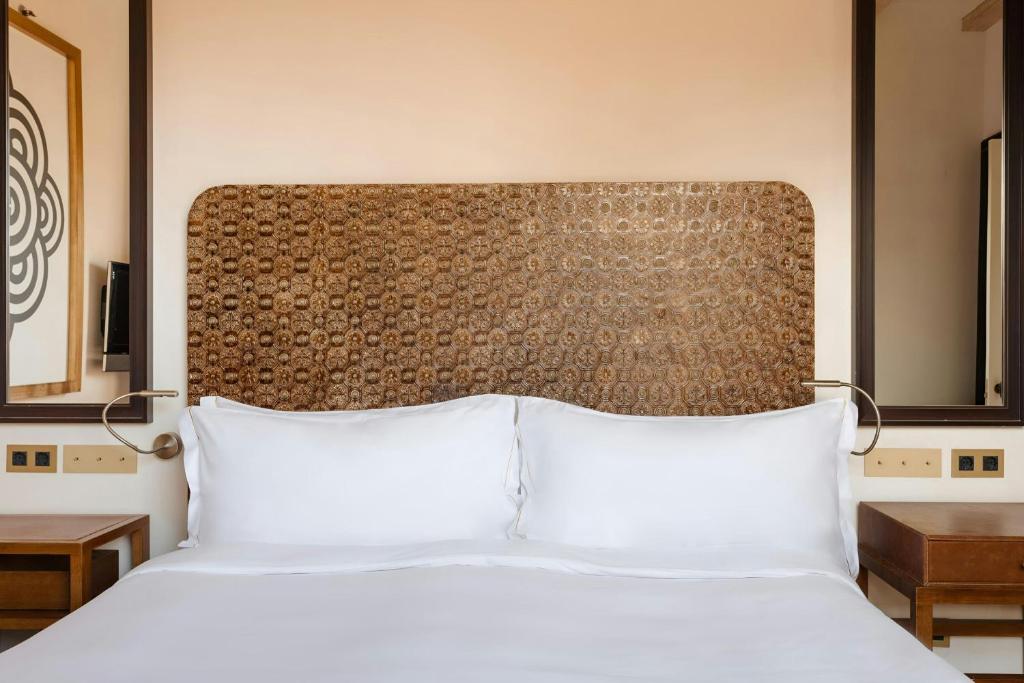 a bed with two white pillows in a hotel room at DO Plaça Reial Hotel Gothic Quarter, Sonder by Marriott Bonvoy in Barcelona