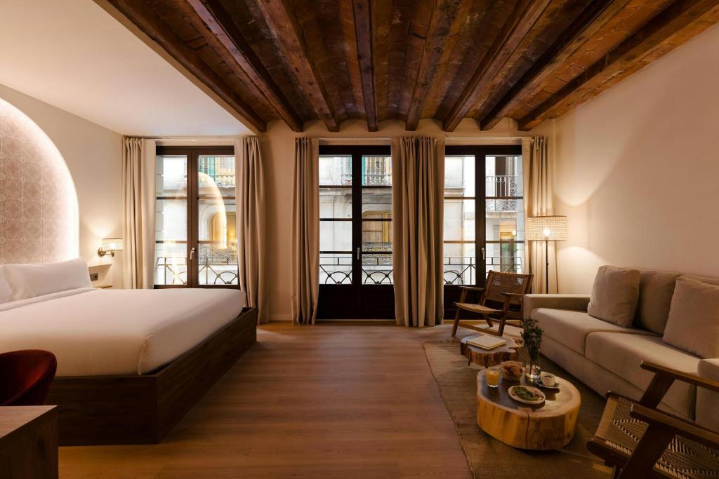a hotel room with a bed and a couch at Hotel Hamsa House in Barcelona