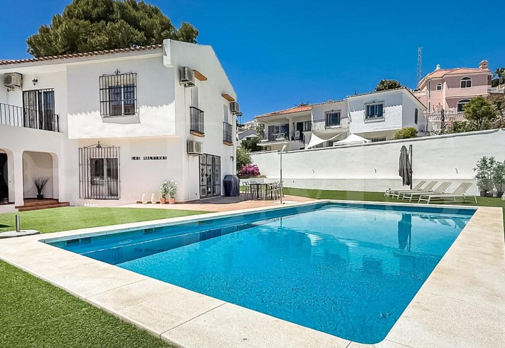 a swimming pool in the yard of a house at Chic Villa with pool, garden and parking REMS in Fuengirola
