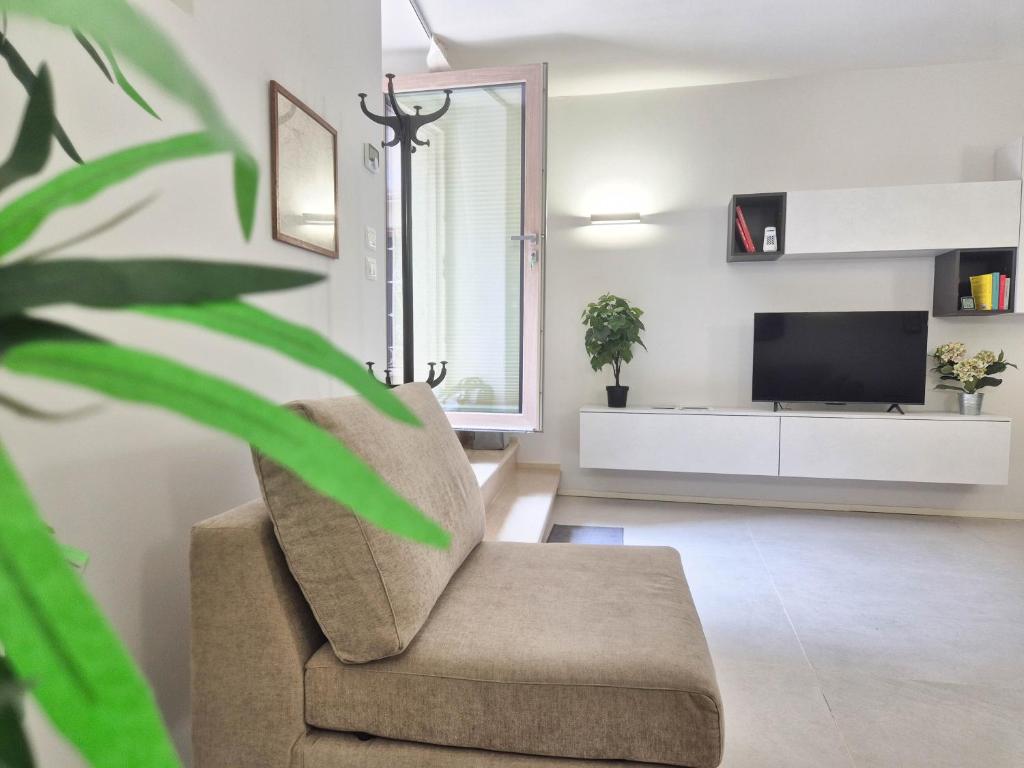 a living room with a chair and a tv at Piazzetta Signori By Case al Lago in Desenzano del Garda