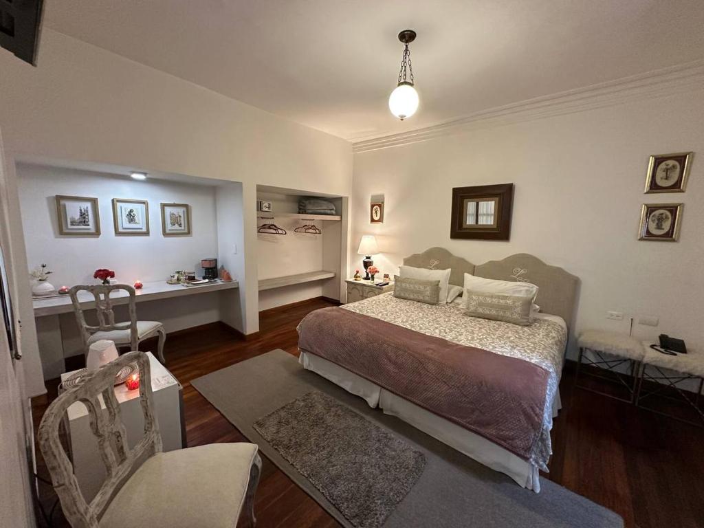 um quarto com uma cama, uma escrivaninha e uma cadeira em Leclerc Hotel Boutique Cali Granada em Cali