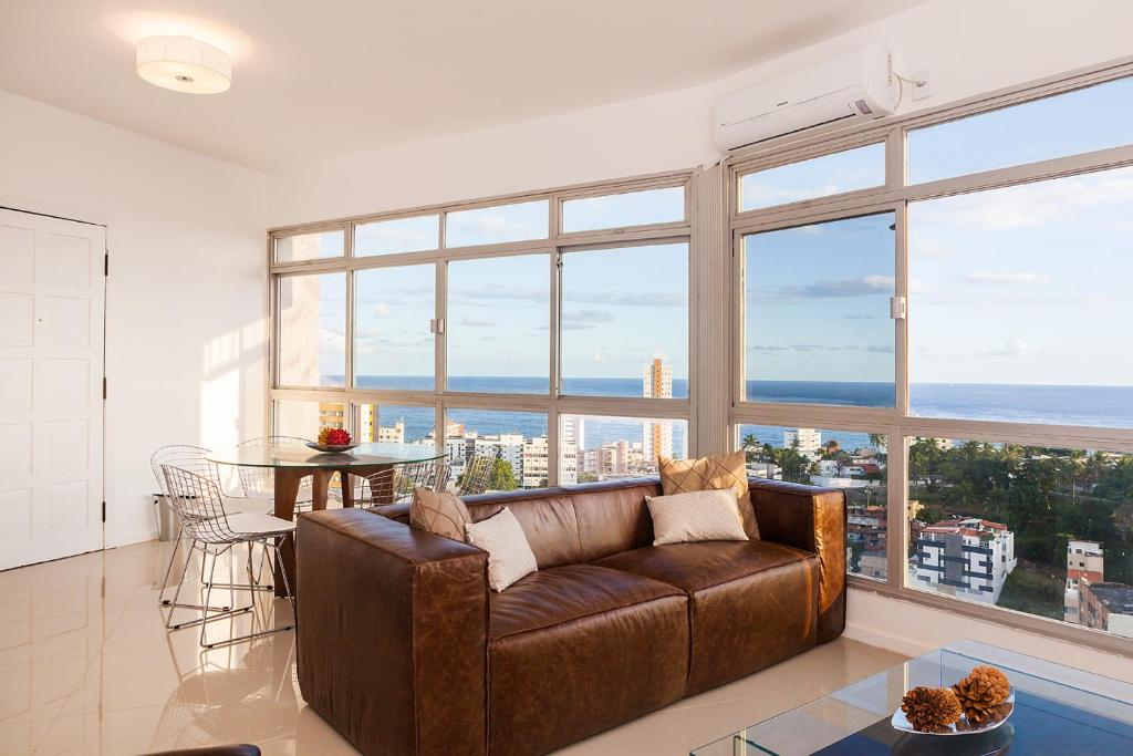 sala de estar con sofá marrón y mesa en Luxury Surround Sea View Apartment, en Salvador
