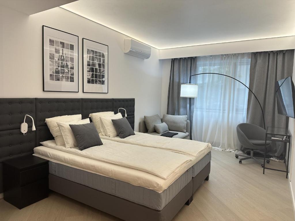 Un dormitorio con una cama grande y una silla. en Urban Nest Pipera, en Pipera