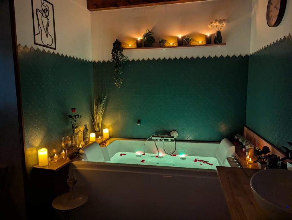 une salle de bain verte avec une baignoire avec des bougies dedans dans l'établissement L'abri du Vercors, à Cognin-les-Gorges