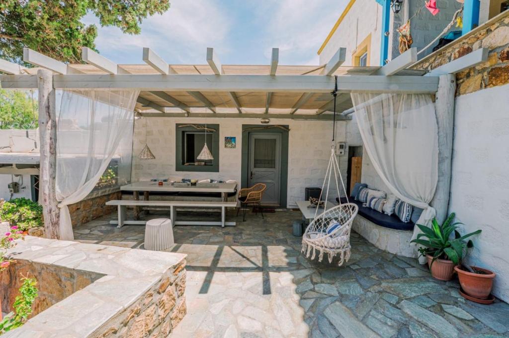 a patio with a table and a swing at Lampi's House in Patmos