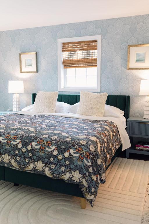 a bedroom with a large bed with a blanket on it at Sea Fog Cottage in Camden
