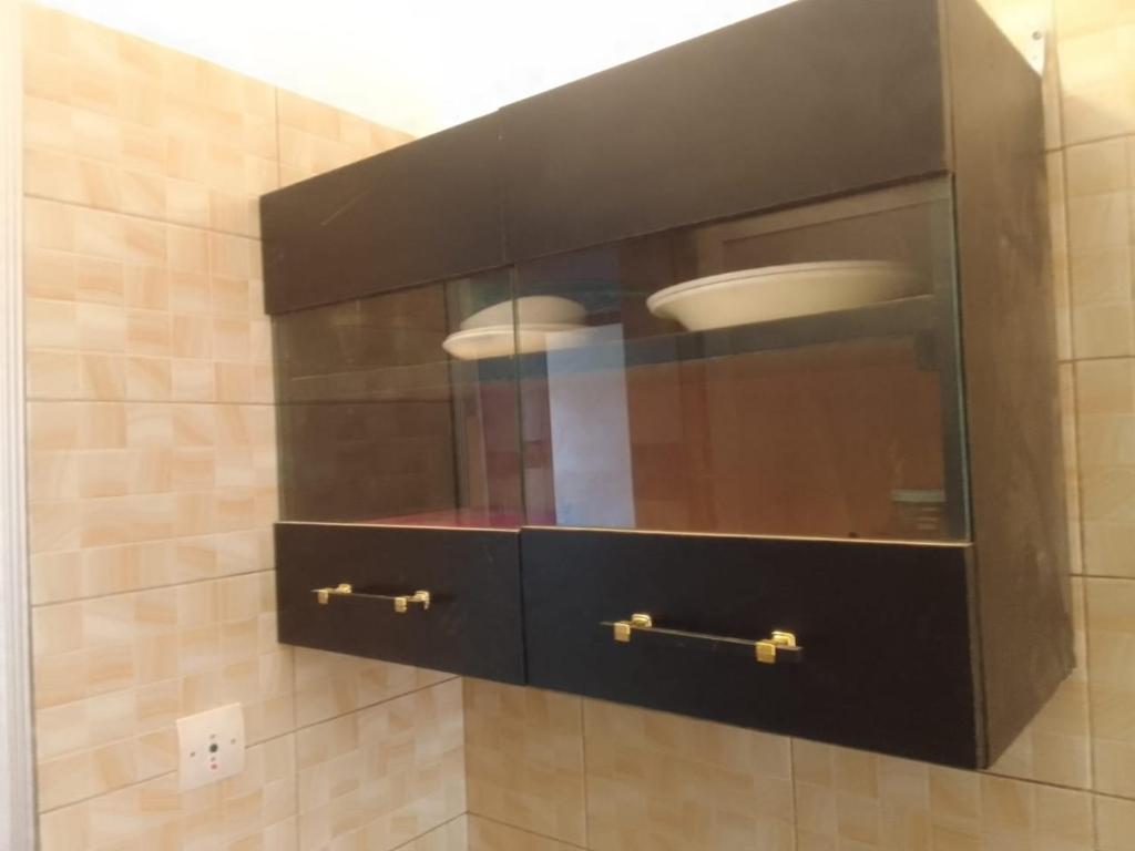 a cabinet with a plate in it in a bathroom at Un T1 CHARMANT in Sangalkam