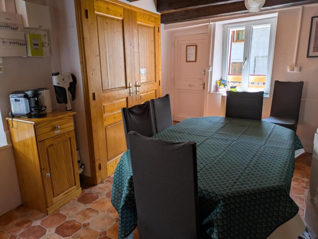 une salle à manger avec une table et des chaises vertes dans l'établissement Sous les Etoiles du Bugey, à Tenay