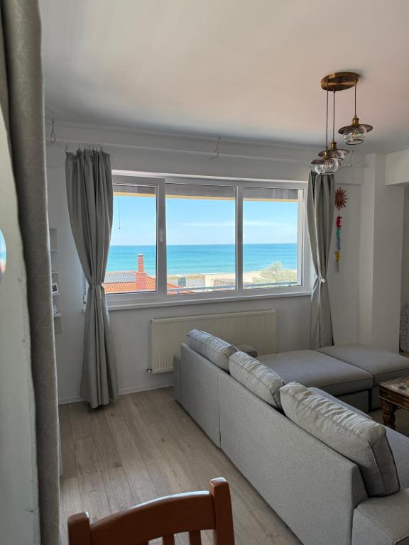 a living room with a couch and a large window at RoApart -Sea VIEW Apartamente 2 camere la 1 min de plaja in Mamaia Nord