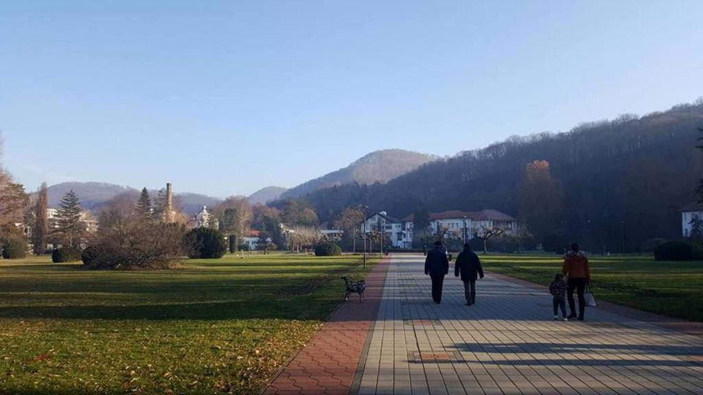 a group of people walking down a sidewalk in a park at Hotel Royal Spa in Banja Koviljača