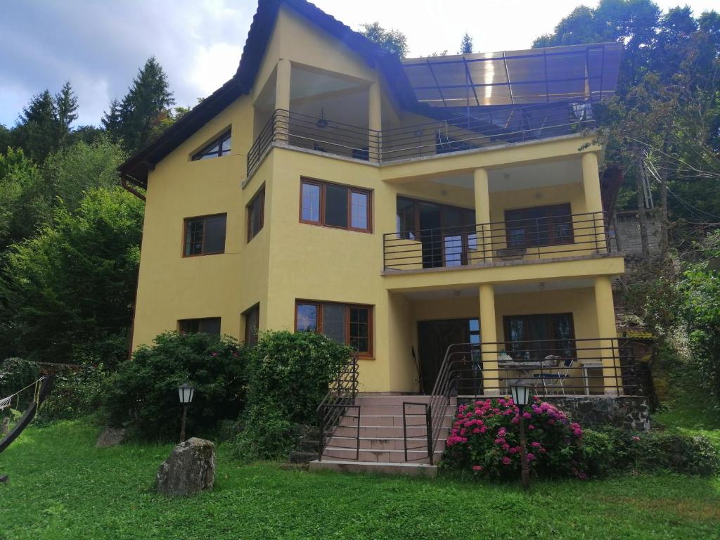 a yellow house with a balcony on top of it at Casa de vacanță Tarnița in Someşu Cald