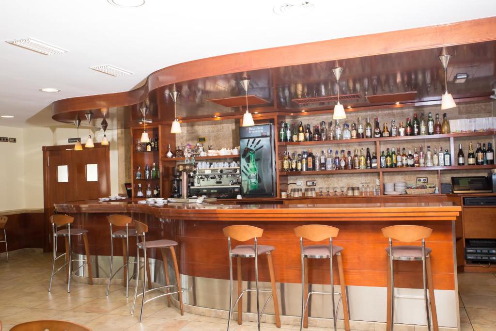 a bar with stools in a room with alcohol at Hotel Noguera El Albir in Albir