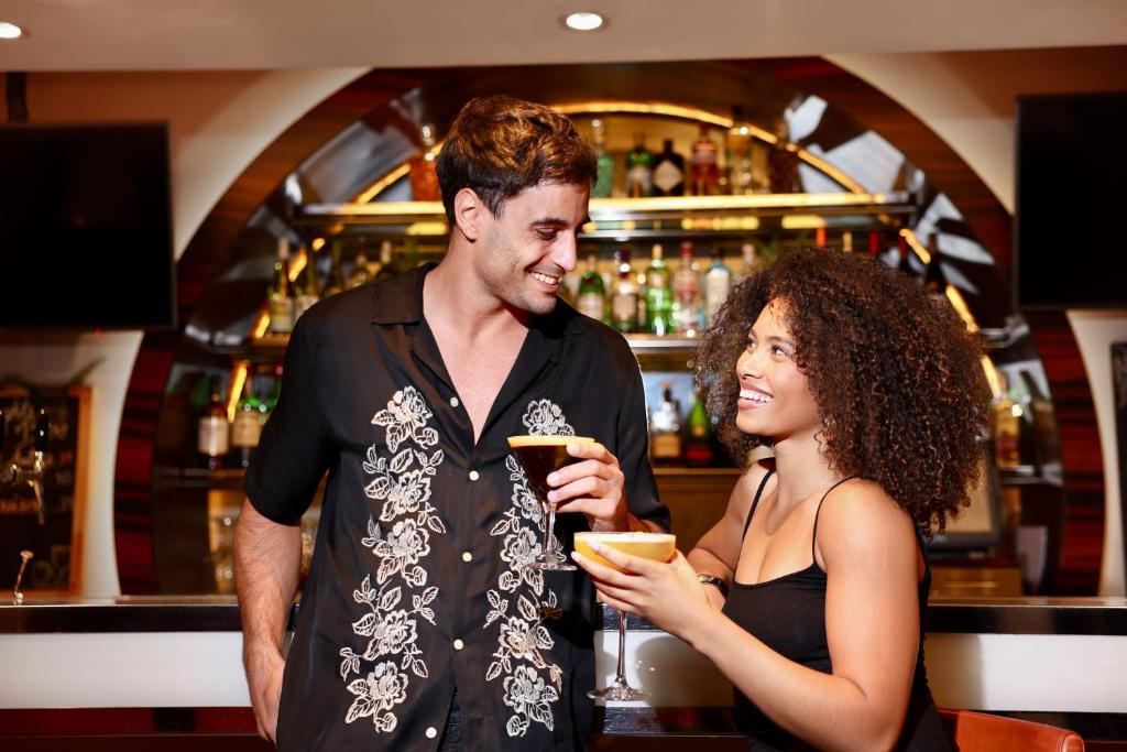 a man and a woman standing in front of a bar at Centro Al Manhal by Rotana in Abu Dhabi