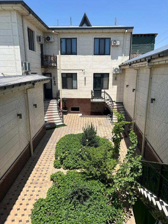 an empty courtyard with plants in front of a building at Avlod Guest House in Samarkand