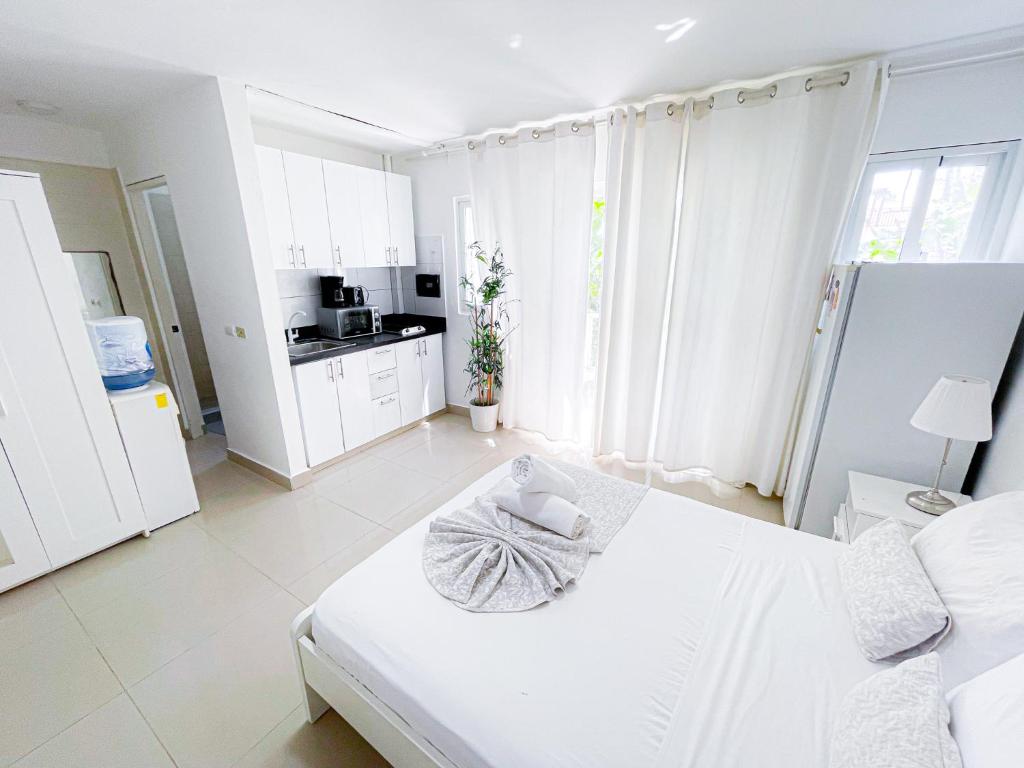 蓬塔卡纳CARIBBEAN Paradise TROPICAL HOTEL with VIEW Los Corales WiFi Beach CLUB & SPA的白色客房 - 带床和厨房