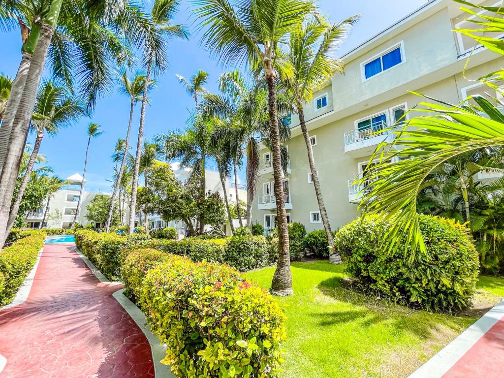 蓬塔卡纳CARIBBEAN Paradise TROPICAL HOTEL with VIEW Los Corales WiFi Beach CLUB & SPA的棕榈树建筑前的走道