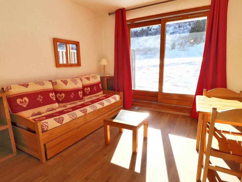 un salon avec un canapé et une fenêtre dans l'établissement Studio Lumineux au Pied des Pistes avec Terrasse Sud - FR-1-182-83, à Méribel