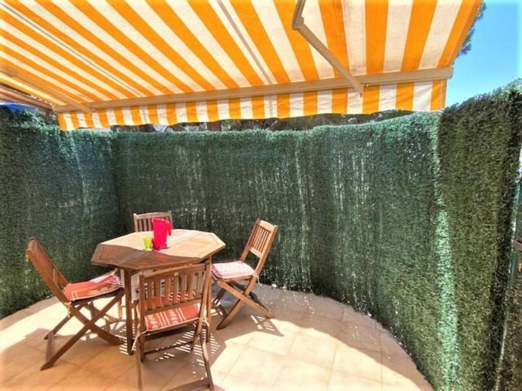 une table avec deux chaises et un mur vert dans l'établissement Le Désirade proche mer, à La Ciotat