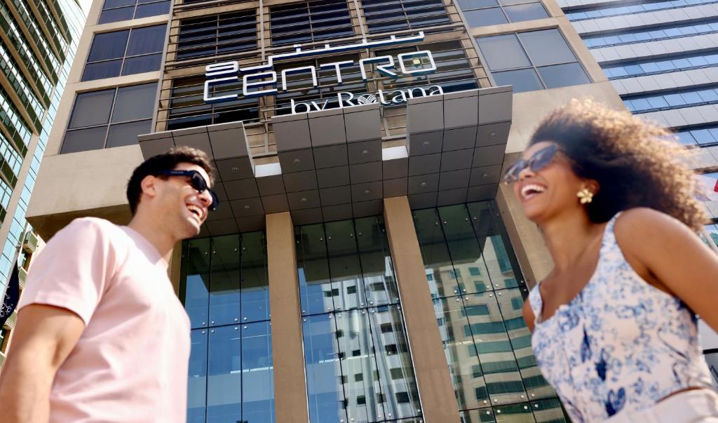 a man and a woman walking in front of a building at Centro Al Manhal by Rotana in Abu Dhabi
