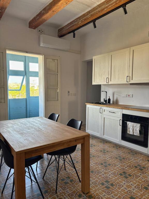 a kitchen with a wooden table and chairs at 4 Borgo Vilhena - Home in Floriana in Il-Furjana