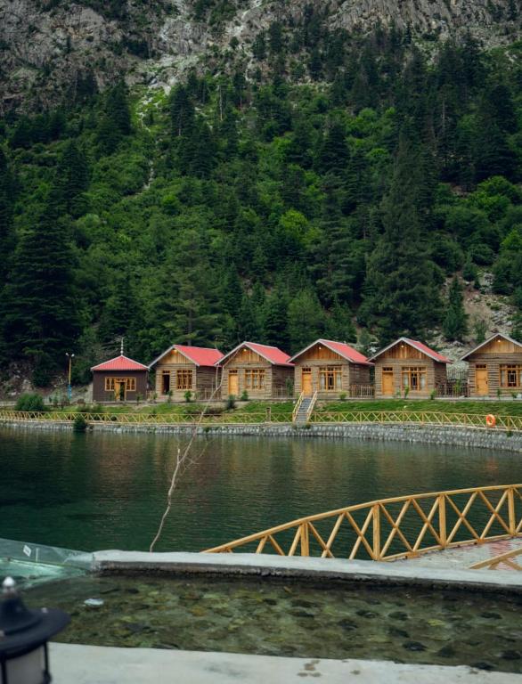a row of wooden houses next to a body of water at Azure Lagoon Resort 