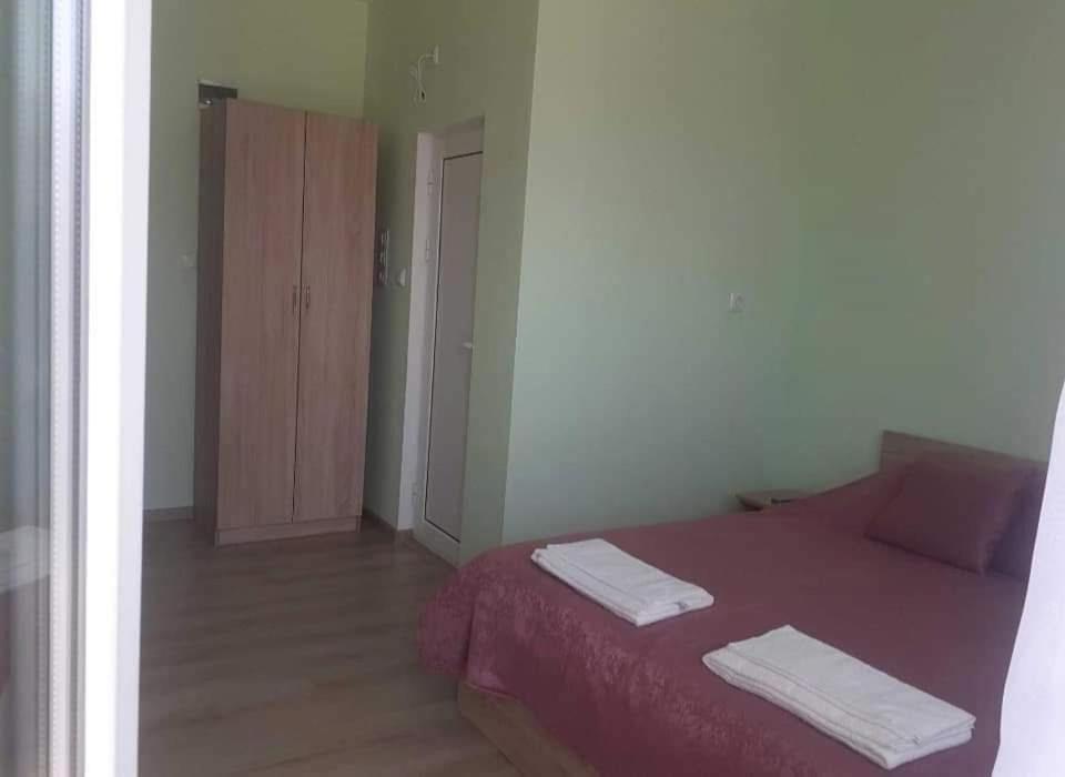 a bedroom with a red bed with two towels on it at Heaven in Draginovo