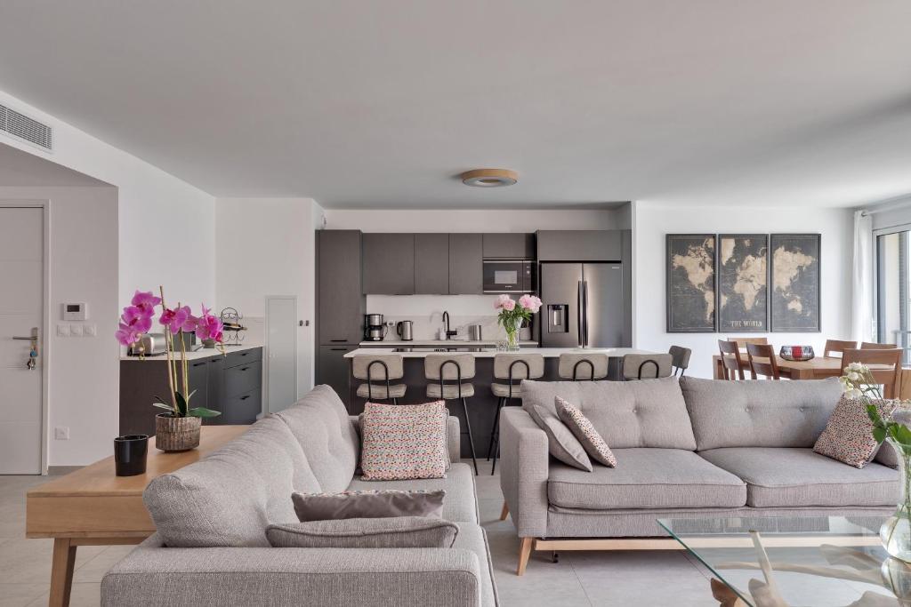 a living room with two couches and a kitchen at Magnifique Rooftop a Antibes 4 chambres in Antibes