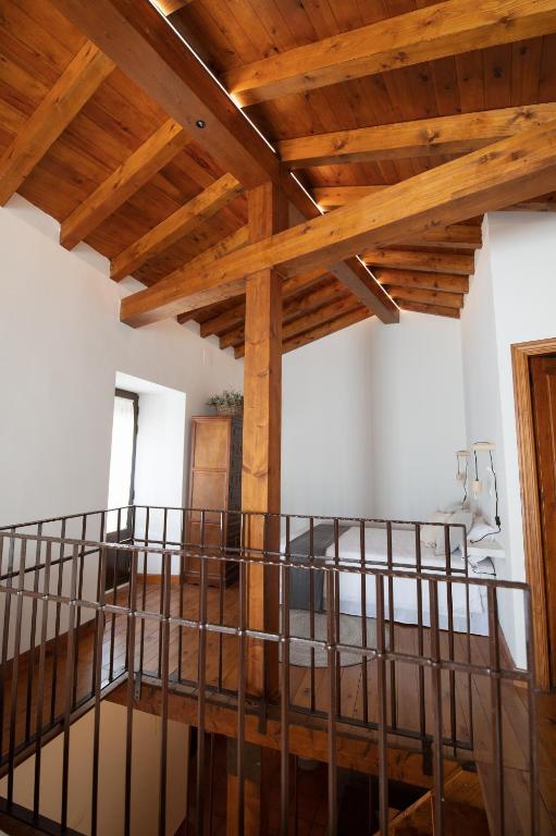 a room with wooden ceilings and a metal bed in it at El Postigo in Trujillo