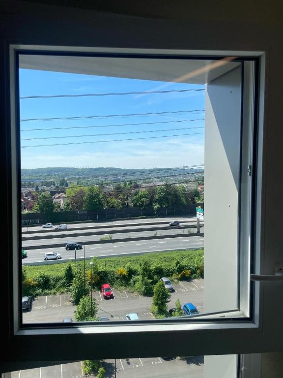 une fenêtre avec vue sur un parking dans l'établissement Bright and peaceful studio with extendable bed, à Palaiseau