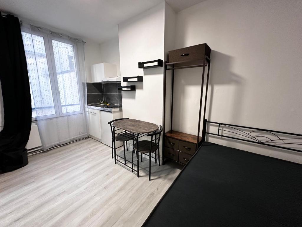 - une cuisine avec une table et un tabouret dans une pièce dans l'établissement Belle Bellot appart 1 room Paris center, à Paris