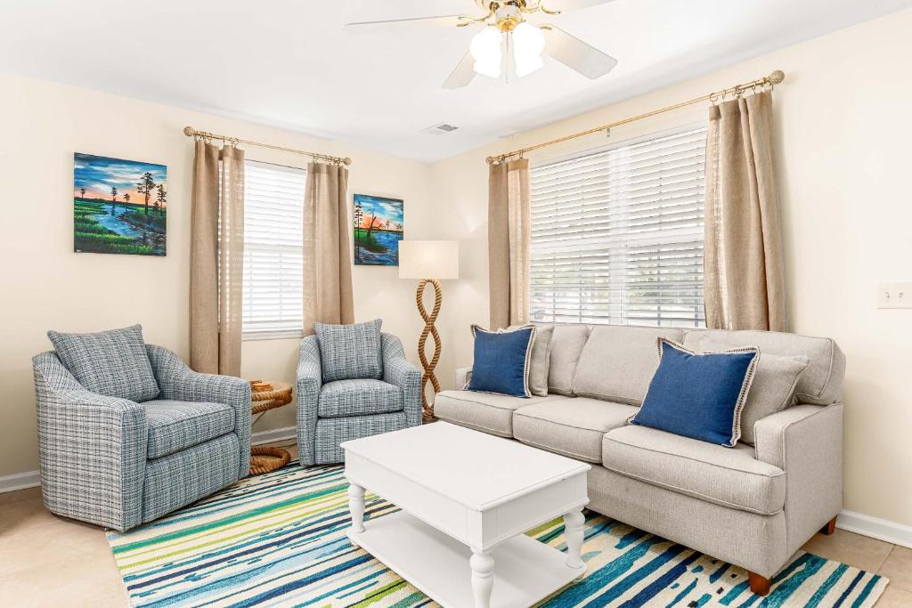 una sala de estar con un sofá y dos sillas en Bowline Bungalow, en Tybee Island