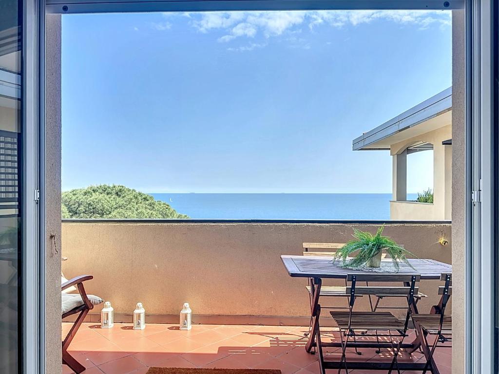 Un patio con una mesa y sillas en un balcón. en Roses House, en Arenzano