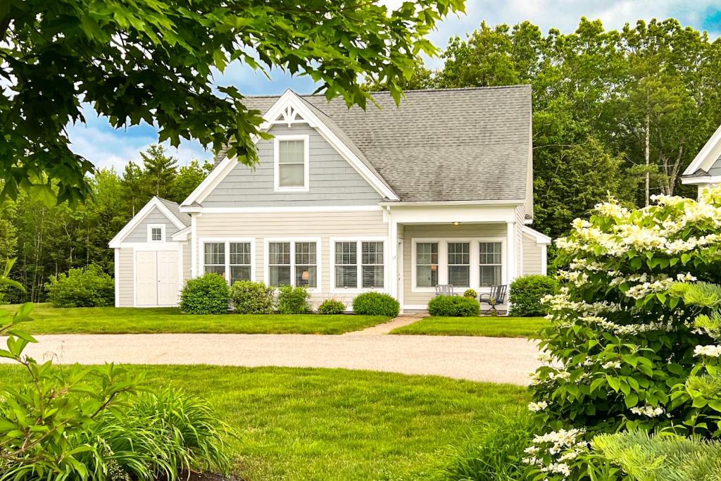 a white house with a driveway at Little Spruce Cottage in Arundel