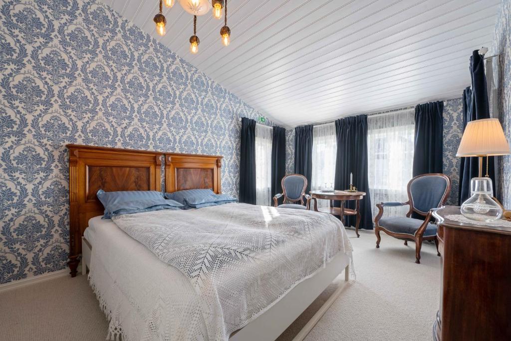 a bedroom with a bed with blue and white wallpaper at Lundins Hotell in Karmøy