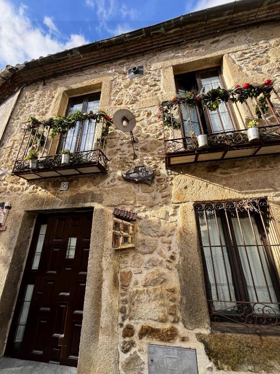 an old stone building with windows and a door at LAS CUATRO CALLES Bis in Piedralaves