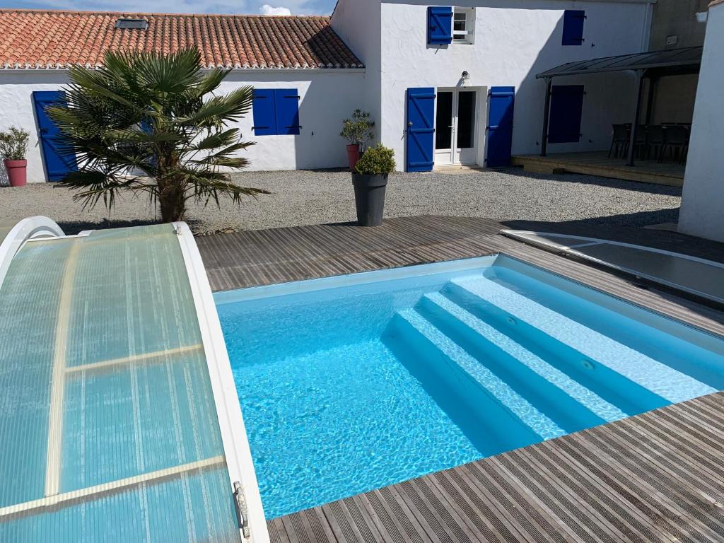 une piscine bleue devant une maison dans l'établissement Maison familiale avec piscine, à Barbâtre
