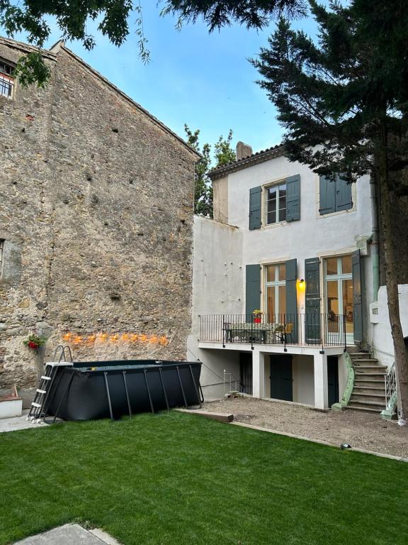 une maison avec un grand mur de pierre et une cour dans l'établissement Maison Hortense Carcassonne, à Carcassonne