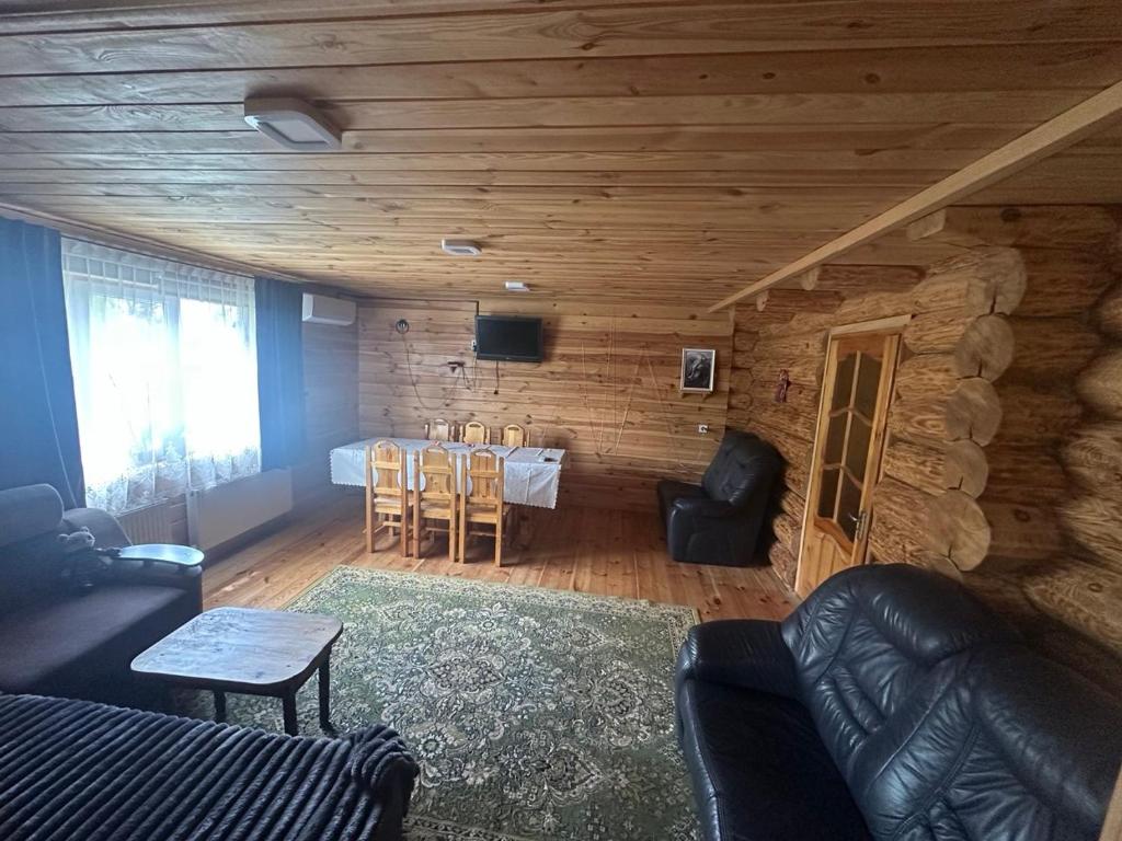 a living room with a table and chairs in a cabin at Лукі in Svityazʼ
