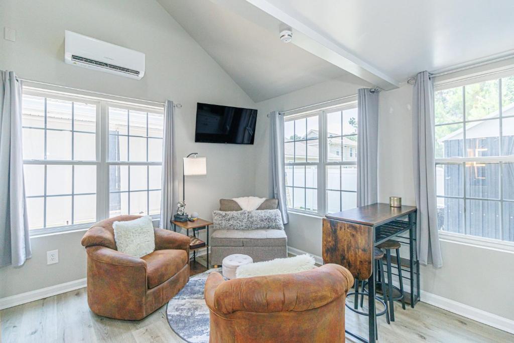 a living room with chairs and a table and windows at Cozy Tiny Home for 2! Short drive to the Beach! in Myrtle Beach