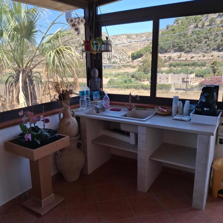 a kitchen with a desk and a large window at La Foggia seaside paradise in Siculiana
