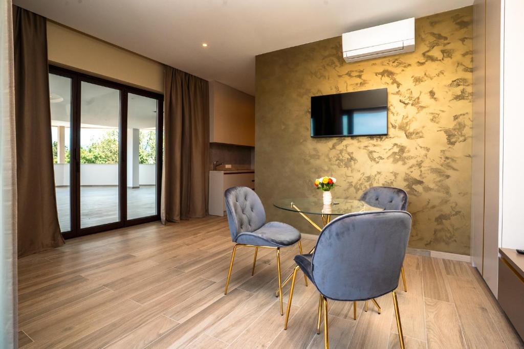 a living room with a glass table and two chairs at VSG Resort - Relaxing Apartments, 200m from the Sea, with Pool, Sauna & Jacuzzi in Klimno
