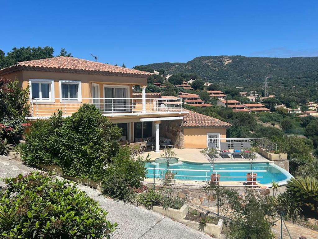une maison avec une piscine devant dans l'établissement Les hauts d'Ou Souleou, villa contemporaine 8 personnes, piscine à débordement, jacuzzi intégré, très belle vue mer et collines, à Bormes-les-Mimosas