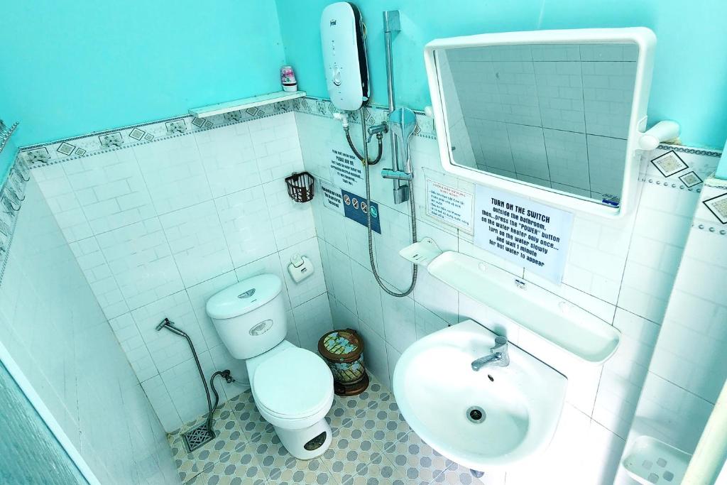 a small bathroom with a toilet and a sink at Hugo's Family in Da Lat