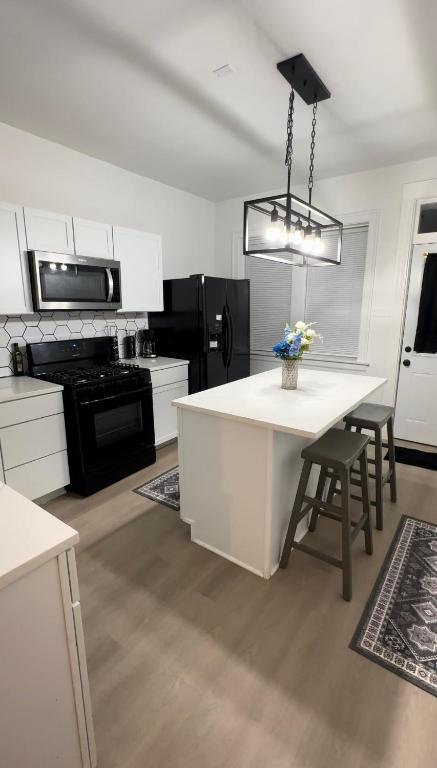 a kitchen with white cabinets and a table with chairs at Cozy Casa by OHare Airport in Chicago
