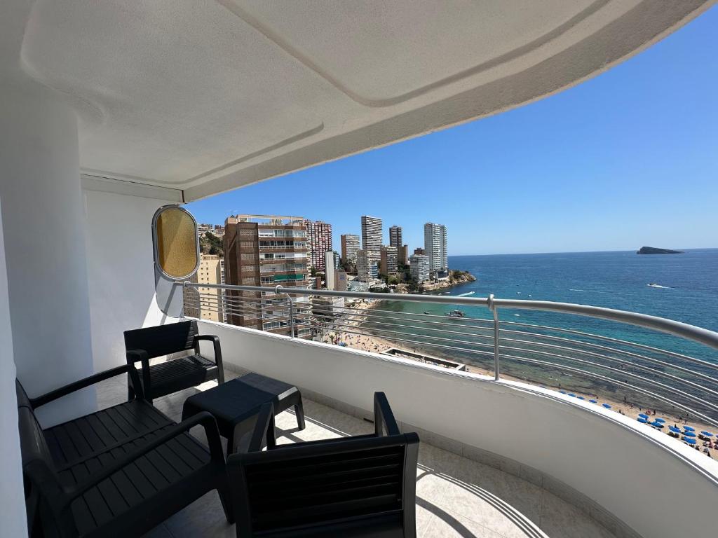a balcony with two chairs and a view of the ocean at BENIDORM SKYLiNE in Benidorm