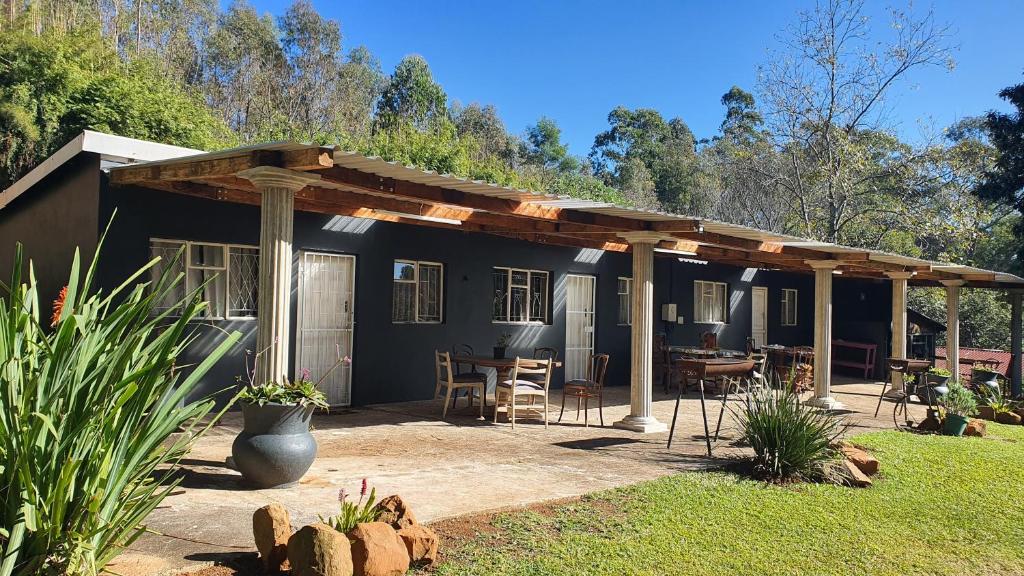 a black house with a wooden pergola at ROCKABILLY RANCH Self-Catering Guest Units in Pietermaritzburg