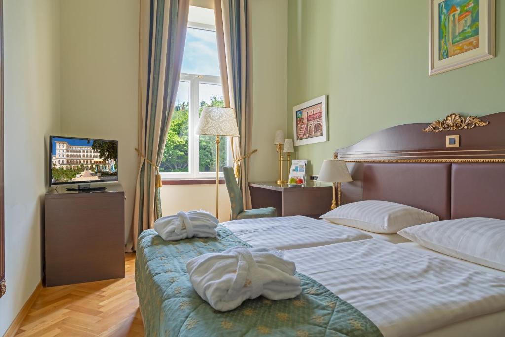 Postel nebo postele na pokoji v ubytování Hotel Kvarner Palace